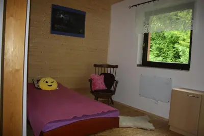 a bedroom with a purple bed and a chair at Chata na řece Sázavě in Samopše
