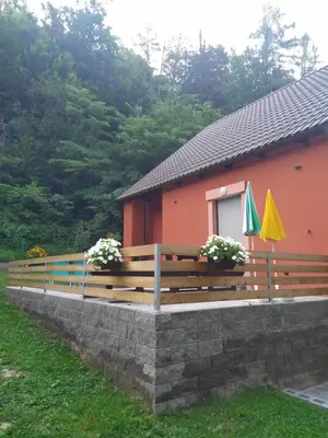 a house with a fence and a patio with umbrellas at Chata na řece Sázavě in Samopše