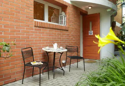 a patio with two chairs and a table in front of a brick building at Villa In Bio Garden - You Will Save Money Here in Prague