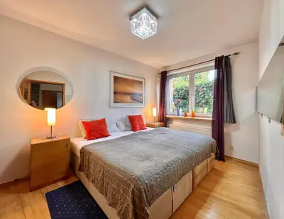 a bedroom with a bed with red pillows and a window at Villa In Bio Garden - You Will Save Money Here in Prague