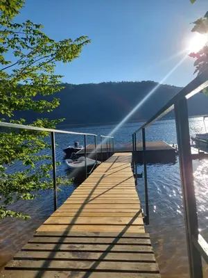 a dock on a lake with a boat in the water at ZÁTOKA Živohošť - Apartmány in Chotilsko