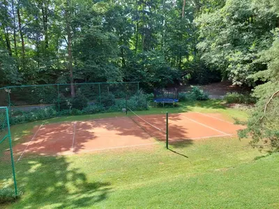a tennis court in the middle of a yard at ZÁTOKA Živohošť - Apartmány in Chotilsko