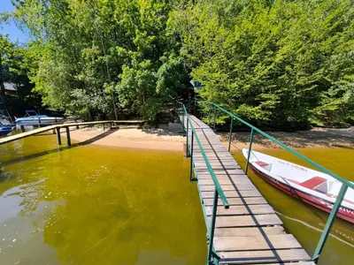 a boat is docked next to a dock in the water at ZÁTOKA Živohošť - Apartmány in Chotilsko