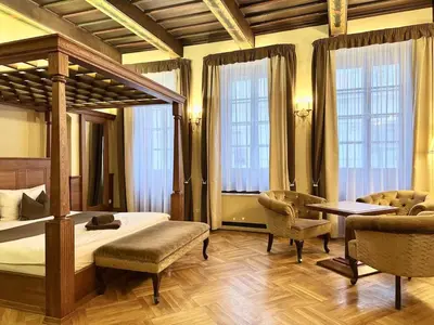 a living room with two chairs and a table and a window at Traditional Prague Apartment in Prague