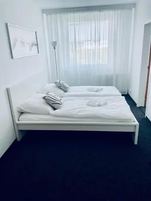 a white bed in a room with a window at Apartmány Bryksova in Prague