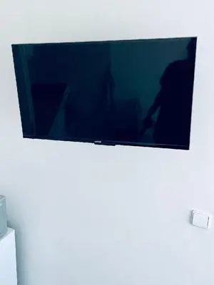a flat screen tv hanging on a white wall at Apartmány Bryksova in Prague