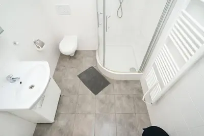 a white bathroom with a sink and a shower at Bright, Spacious Apartment in the Historic Centre in Prague