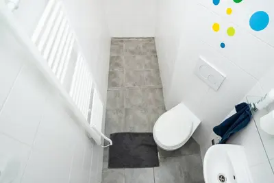 a white bathroom with a toilet and a sink at Bright, Spacious Apartment in the Historic Centre in Prague