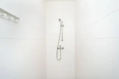 a bathroom with a shower with white tiles at Bright, Spacious Apartment in the Historic Centre in Prague