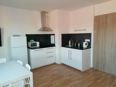 a kitchen with white cabinets and a white refrigerator at One bedroom penthouse apartment # 82 in the brand new building close to the city center with free parking in Prague