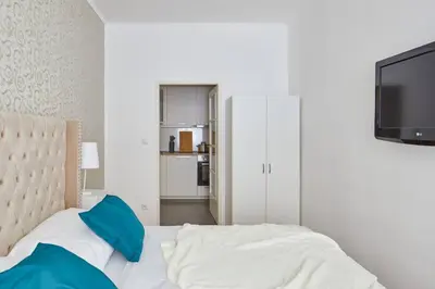 a bedroom with a bed with blue pillows and a tv at Gentle and cozy apartment right at the Center Prague in Prague