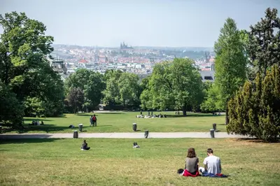 a group of people sitting in the grass in a park at LIKE AT HOME IN CENTER OF PRAGUE in Prague