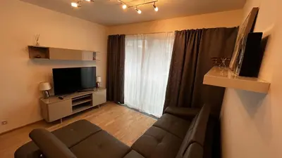a living room with a couch and a television at Residence Garden Tower - 8 min do centra, garaz in Prague