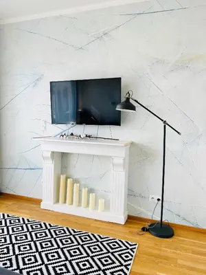 a living room with a tv on a white wall at White Pearl Studio with parking in Holešovice in Prague