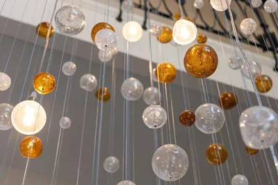 a bunch of glass balls hanging from a ceiling at Allure Hotel & Residence Prague in Prague