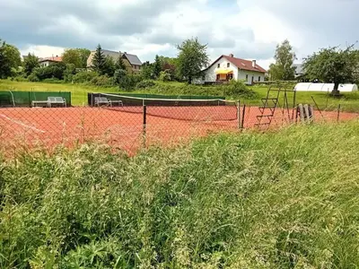 a tennis court with a net in a field at Apartmán Chrpa in Snědovice
