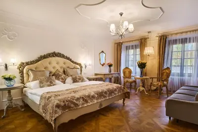 a bedroom with a large bed and a living room at Spa Beerland Chateaux – U Zlaté Hrušky / At Golden pear in Prague