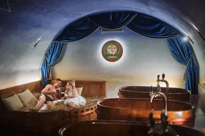 a man and woman sitting in a room with a tub at Spa Beerland Chateaux – U Zlaté Hrušky / At Golden pear in Prague