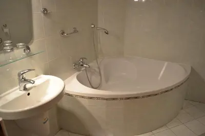 a bathroom with a bath tub and a sink at Hotel Na Statku in Nepřevázka