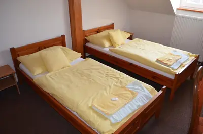 two twin beds in a room with at Hotel Na Statku in Nepřevázka
