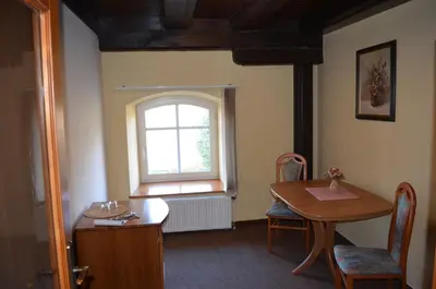 a room with a wooden table and a window at Hotel Na Statku in Nepřevázka
