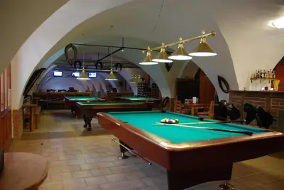 a row of pool tables in a room with an arcade at Hotel Na Statku in Nepřevázka