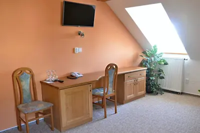a room with a desk with two chairs and a tv at Hotel Na Statku in Nepřevázka