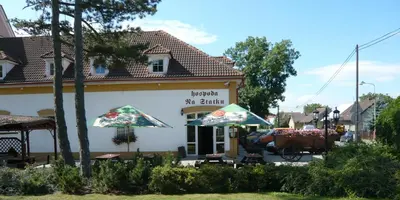 a building with two umbrellas in front of it at Hotel Na Statku in Nepřevázka