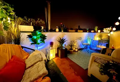 a living room with a couch on a balcony at night at Duplex 2 with quiet terrace on Wenceslas Square in Prague