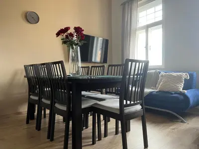 a dining room table with chairs and a vase of flowers at Old Town Square Apartments in Prague