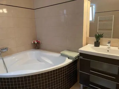a bathroom with a large tub and a sink at Old Town Square Apartments in Prague