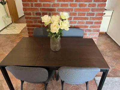 a vase of flowers on a wooden table with two chairs at Old Town Square Apartments in Prague