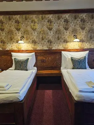 two twin beds in a room with a wall at Hotel Galerie in Roudnice nad Labem