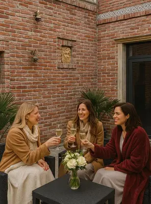 three women sitting around a table with glasses of wine at Hotel Galerie in Roudnice nad Labem