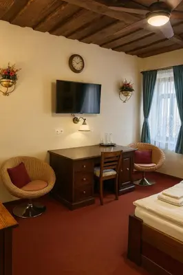 a hotel room with a desk and two chairs at Hotel Galerie in Roudnice nad Labem