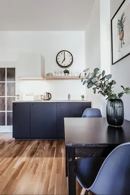 a kitchen with a table and a clock on the wall at TurnKey I King George Square Studio in Prague