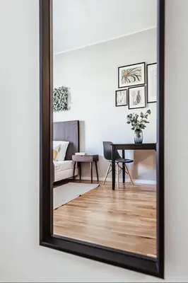a mirror hanging on a wall in a living room at TurnKey I King George Square Studio in Prague