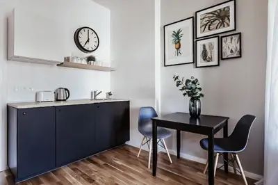 a kitchen and dining room with a table and chairs at TurnKey I King George Square Studio in Prague