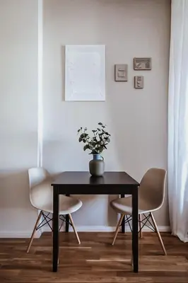 a dining room table with two chairs and a vase with flowers at TurnKey I King George Square Studio in Prague