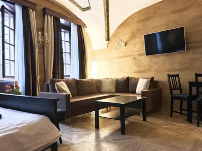 a living room with a couch and a tv on a wall at Unique Prague Apartment in Prague