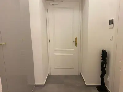 a hallway with a white door and a stair case at NaNa Flat in Prague