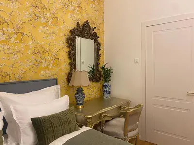 a bedroom with a mirror and a bed and a table at NaNa Flat in Prague