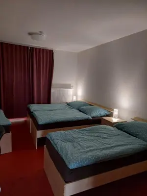 a hotel room with three beds and a window at Penzion na hřišti in Radím