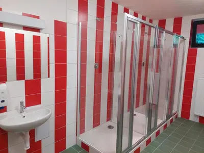 a red and white bathroom with a shower and a sink at Penzion na hřišti in Radím