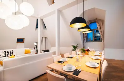 a dining room with a table and a couch at LUX Penthouse Apartments near Wenceslas Square in Prague
