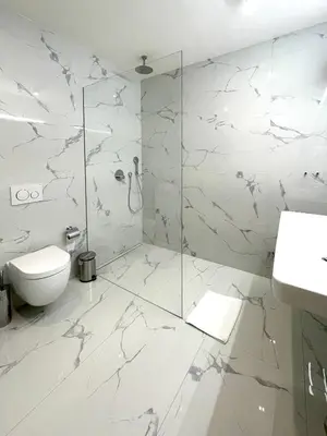 a white bathroom with a shower and a toilet at Štupartská - Attic Old Town Residence in Prague