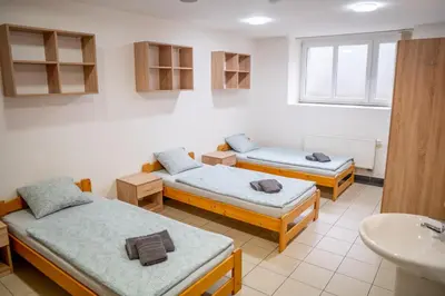 a room with three beds and a sink at Penzion Pomeranč in Louny
