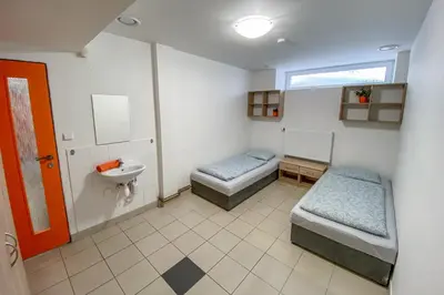 a bathroom with two beds and a sink at Penzion Pomeranč in Louny