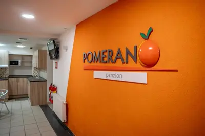 an orange wall in a kitchen with an apple on it at Penzion Pomeranč in Louny