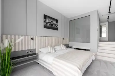 a white bedroom with a large bed and a window at Port Karolina Luxury Residence in Prague